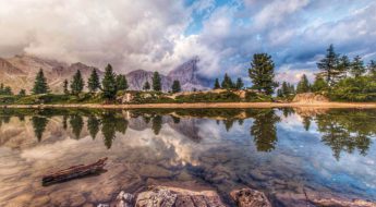 A body of water with trees and mountains in the background.