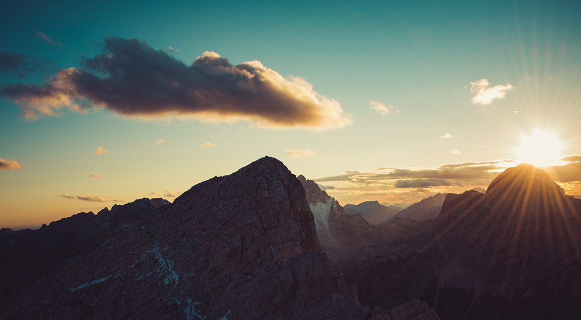 A mountain range with a cloud in the sky.