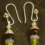 A pair of earrings with green beads and silver accents.