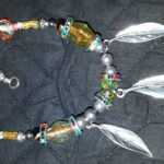 A necklace with feathers and beads on it.