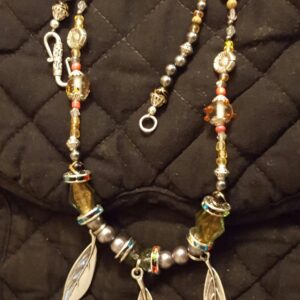 A necklace with leaves and beads on it.