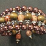 A bracelet with brown and green beads on it.