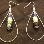 A pair of earrings with blue and yellow beads.