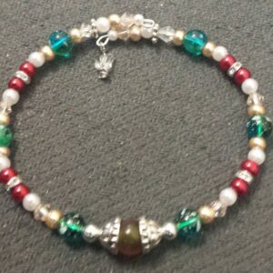 A bracelet with green and red beads on it.