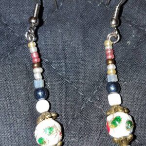 A pair of earrings with beads and flowers.