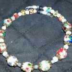 A necklace with colorful beads and white glass beads.