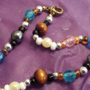 A purple cloth with beads and a key chain