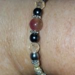 A close up of the wrist with beads