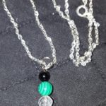 A necklace with a coin and beads on it