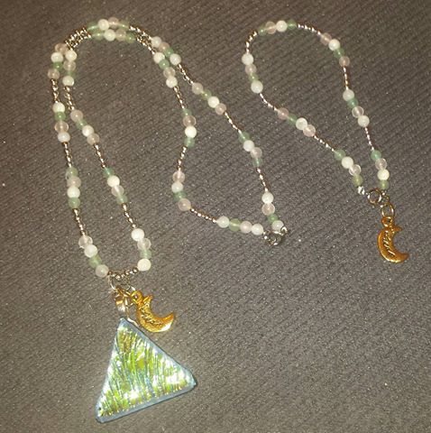 A necklace with two charms and one is a triangle.