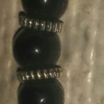 A close up of the black beads on a white surface