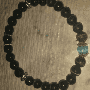 A black bead bracelet with silver and blue beads.