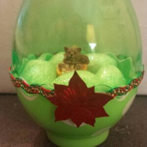 A green glass bowl with a leaf decoration on top.