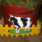 A cow is standing in front of a pot.