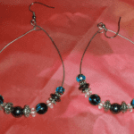 A pair of earrings with blue and clear beads.