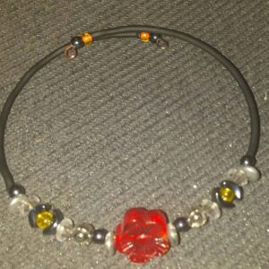 A red bead necklace with yellow and clear beads.