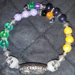 A bracelet with skulls and beads on it.