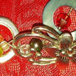 A close up of some jewelry on a red cloth