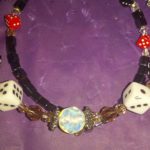 A necklace with dice and other beads on it.