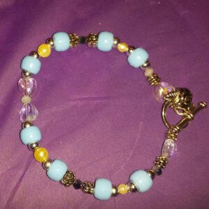 A bracelet with blue beads and yellow accents.