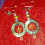 A pair of earrings sitting on top of a red cloth.