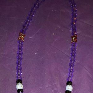 A purple necklace with gold and black beads.