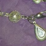 A close up of the silver chain with a drop and a ball