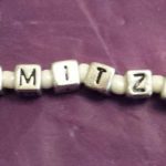 A close up of the word mitzv spelled out in beads