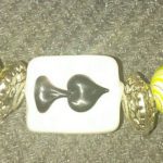 A close up of a yellow and white bead