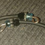 A pair of black cords with blue beads on them.