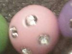 A pink ball with some silver dots on it