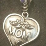 A heart shaped charm with the word mom on it.