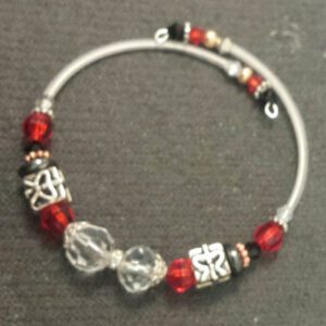 A bracelet with red and black beads on it.