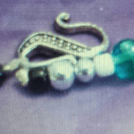 A close up of the key chain with a green bead