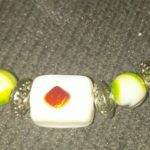 A close up of a bracelet with two beads