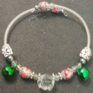 A bracelet with green and red beads on it.