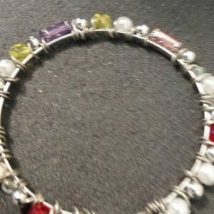 A bracelet with many different colored stones and pearls.