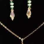 A necklace and earrings set with green beads.