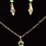 A necklace and earrings set with green stones.