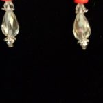 A pair of earrings with red and clear beads.