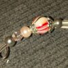 A key chain with beads and silver metal.