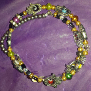 A bracelet with different colored beads and silver hamsa.